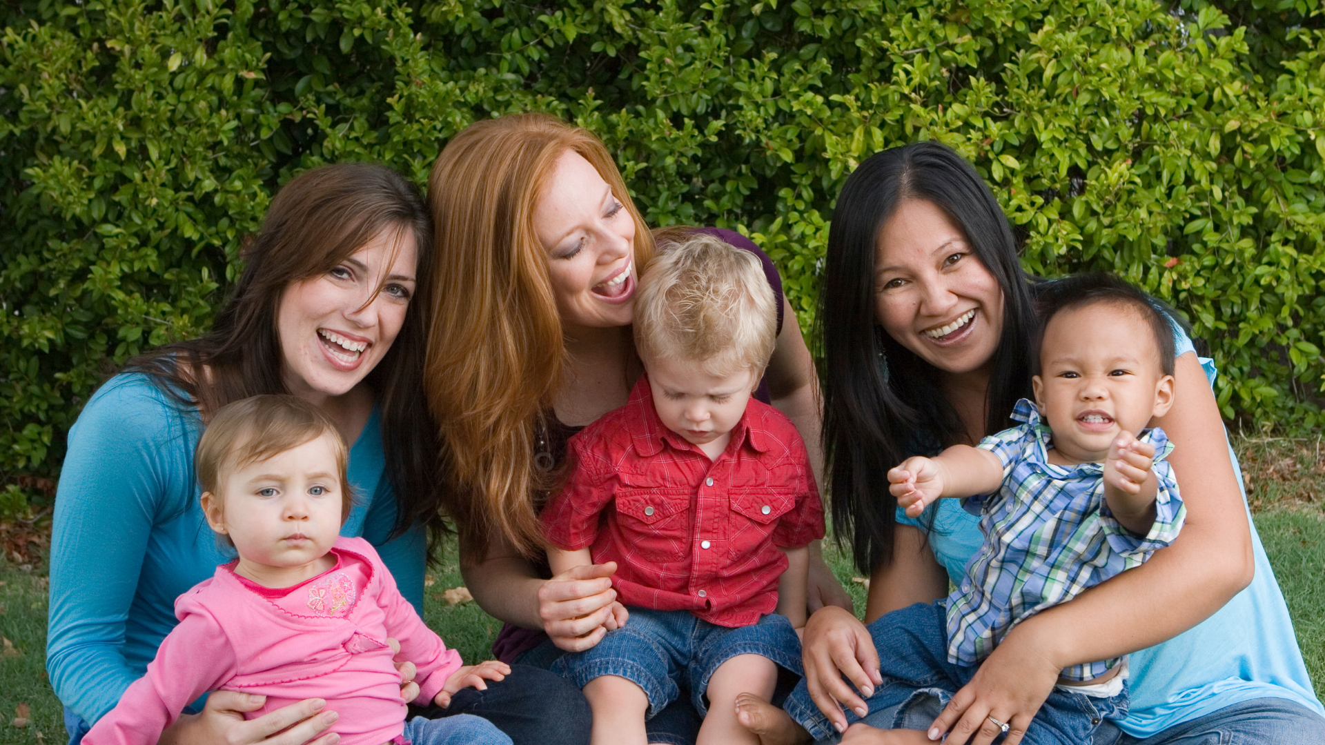 Moms sitting outside with their kids.